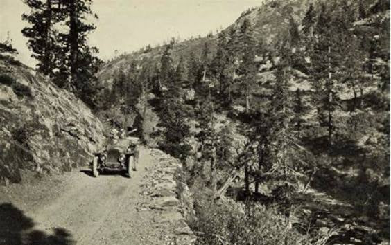 A vintage automobile navigating the narrow canyon road — one of the corridors that connected remote Sierra communities