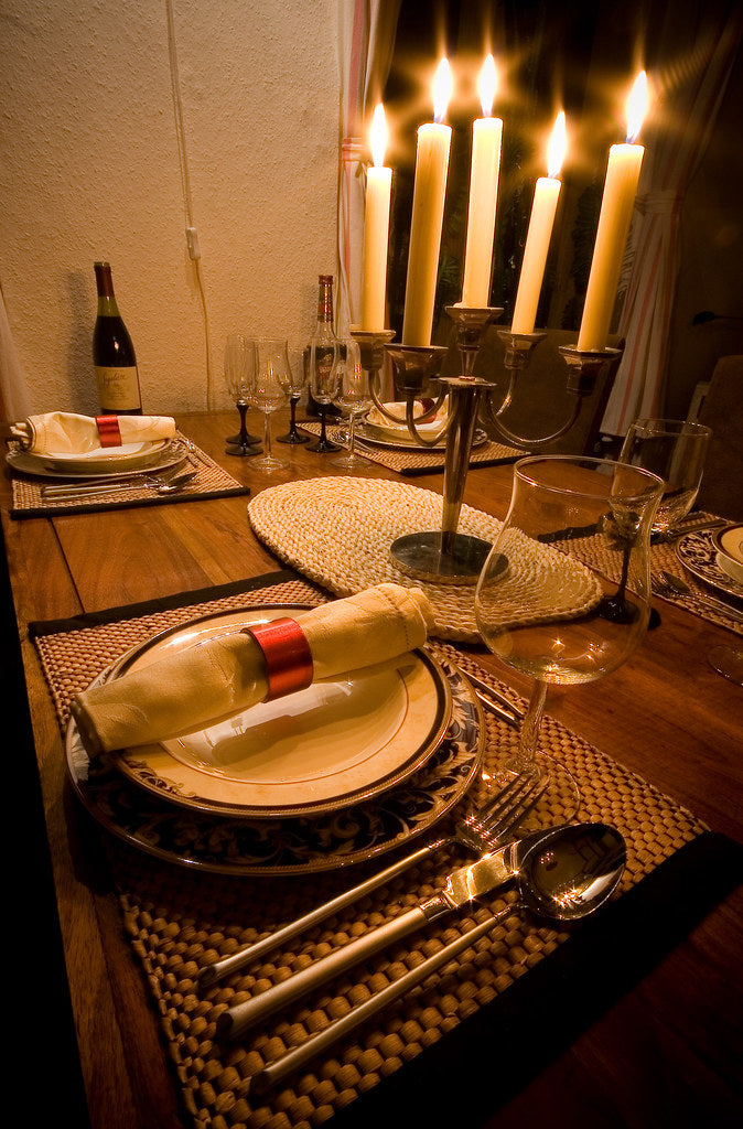 A candlelit dinner table set for two with wine